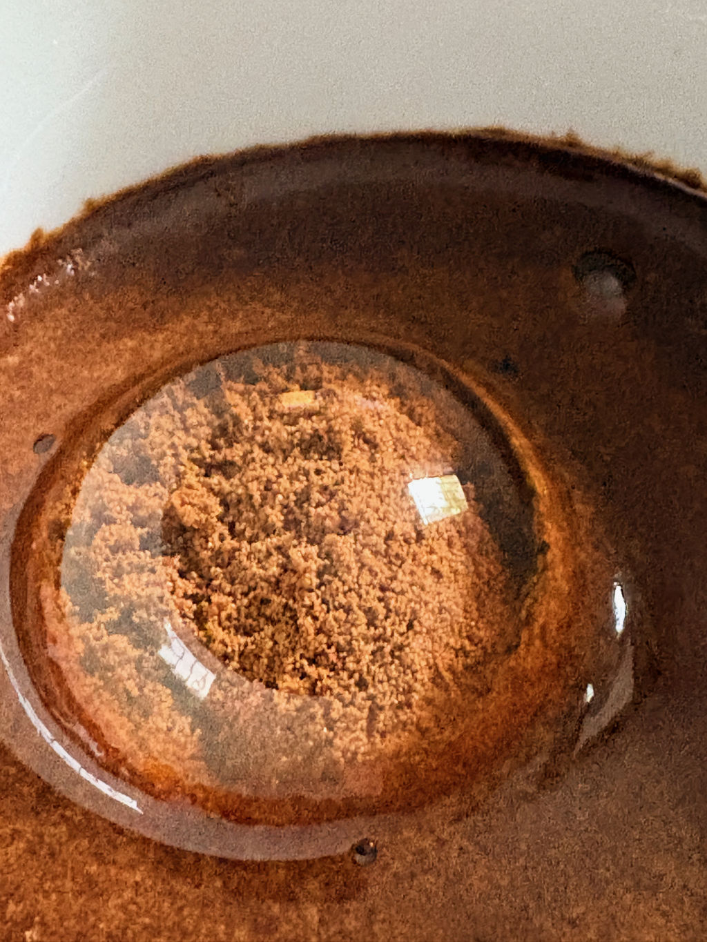 Dettaglio ravvicinato della cupola d'acqua: si vedono il margine della membrana e due riflessi di finestra dai bordi netti.
